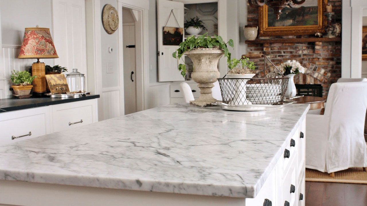 white granite countertops adorn this modern kitchen and highlight the black backsplash and white trimmings.